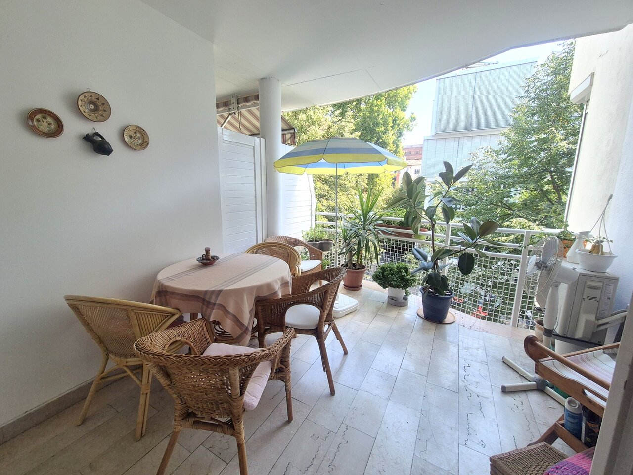 A lakás 9,5 m²-es fedett terasza kerti bútorokkal és növényekkel